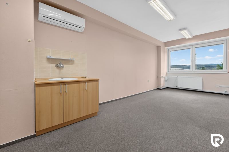 Office with a sink, air conditioning, and a view of the hills; bright walls and carpet.