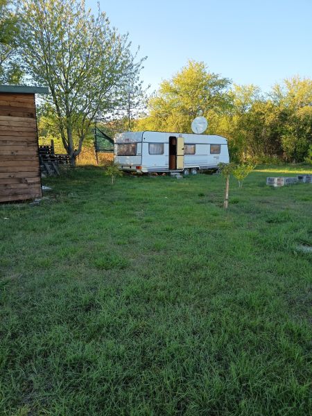 A caravan in the gardens on Tatranská Street in Zlaté Moravce surrounded by trees and a grassy area.