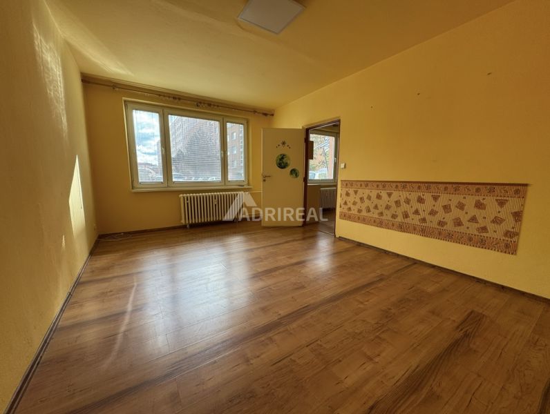 A room with a wooden floor decor in a studio apartment and yellow walls.