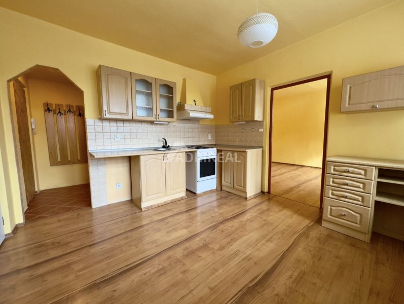 A kitchen unit with a gas stove and a wooden decor floor in a studio apartment.