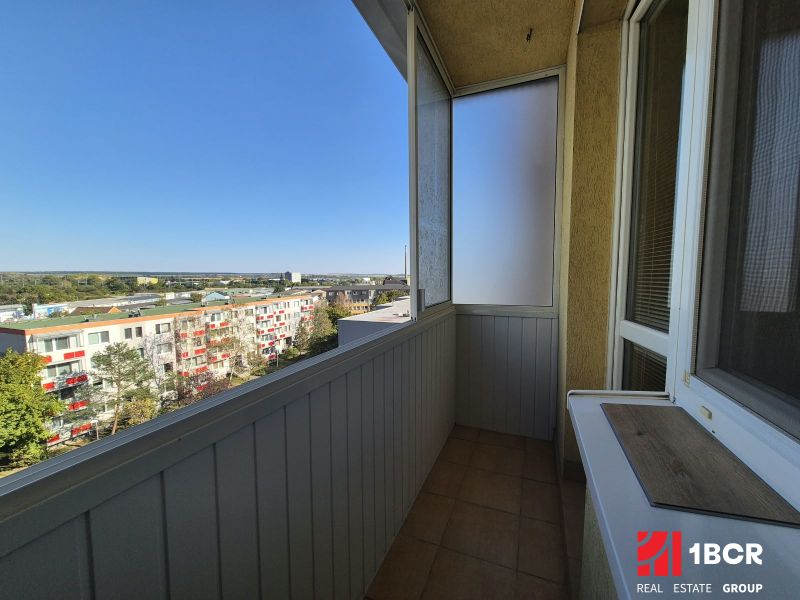 A balcony of a studio apartment with a view of Bystrická Street in Pezinok, sunny day.