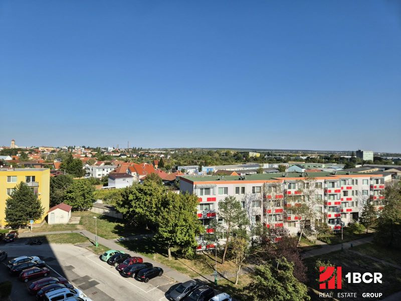 View of Bystrická Street in Pezinok with studio apartments and greenery.