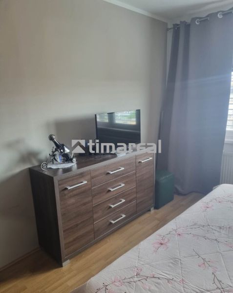 Interior of a 3-room apartment with a dresser and a television, floor with wooden decor.
