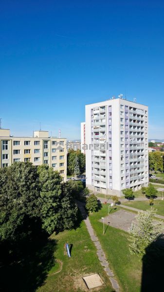 View of apartment buildings and greenery in Trnava, ideal for a 3-room apartment.