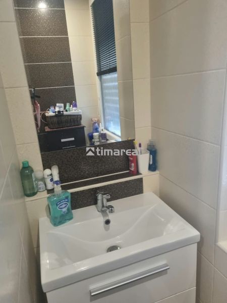Bathroom in a 3-room apartment with a stylish sink and shelves for accessories.