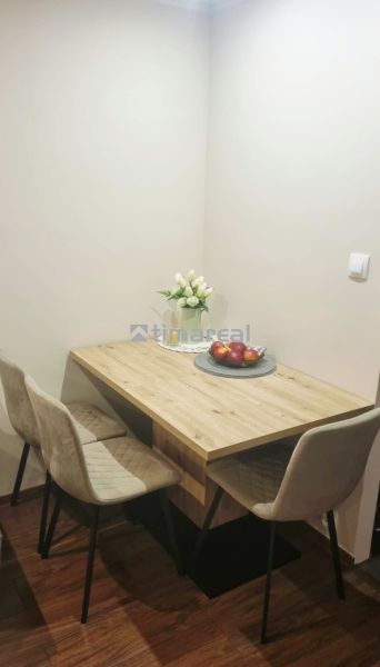 Dining area in a 3-room apartment with a wooden decor floor and decorations.