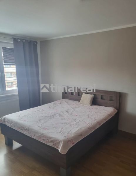 A bedroom in a 3-room apartment with a bed and a wooden decor floor.