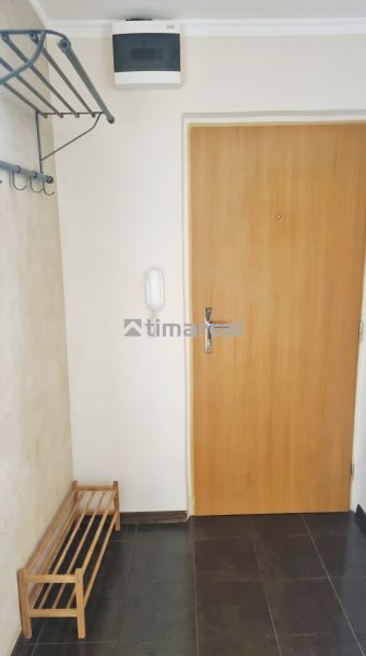 Entrance hallway in a 3-room apartment with a coat rack, shoe cabinet, and wooden door.
