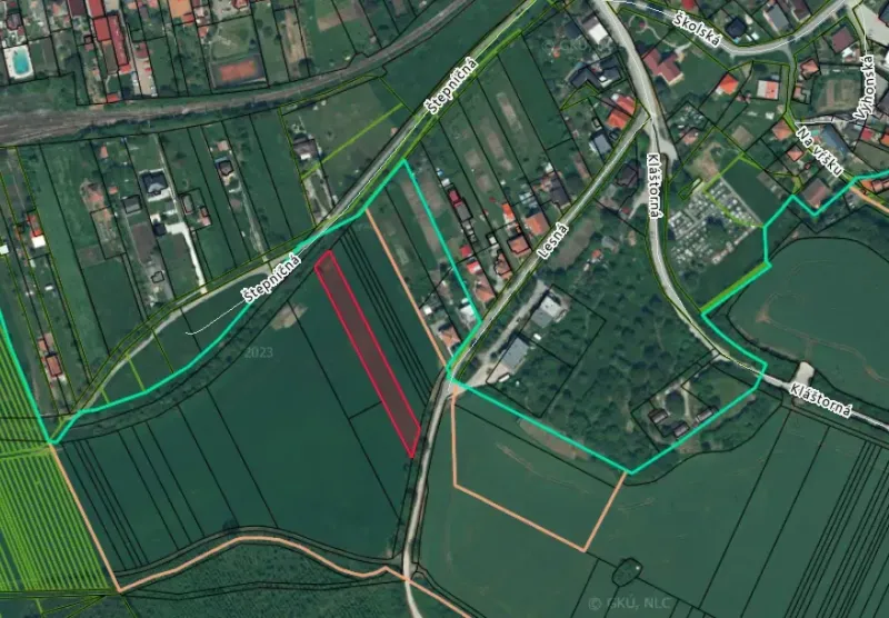 Aerial view of agricultural and forest lands in Podhájska with visible road network.