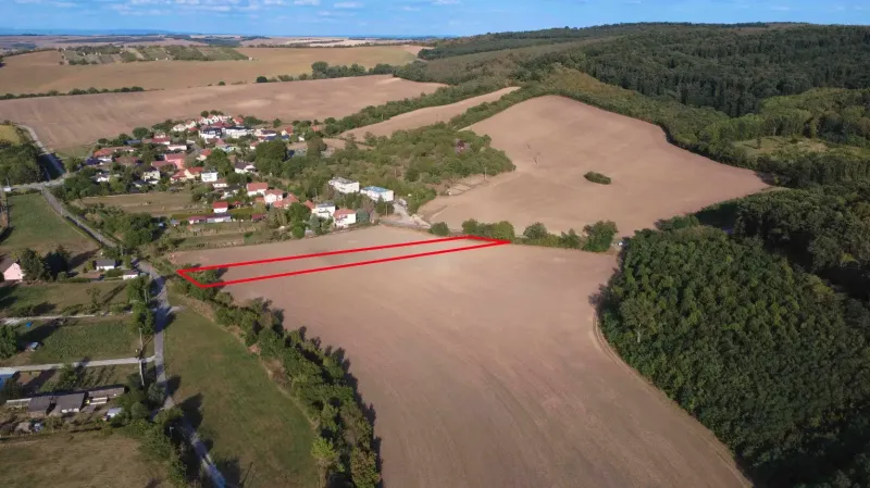 Aerial view of agricultural and forest lands near Podhájska surrounded by the village and forest.