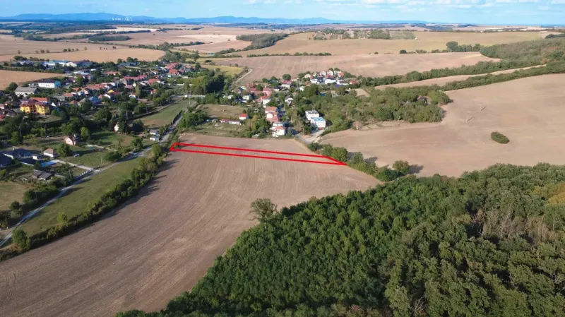 Aerial view of agricultural and forest lands in Podhájska surrounded by the village and nature.