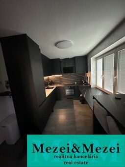 A modern kitchen in a 2-room apartment with an elegant design and large windows.