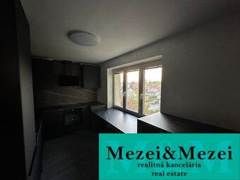 A kitchen in a 2-room apartment with dark furniture and a view from the window.