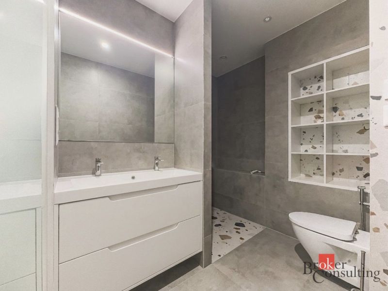 Bathroom in a 3-room apartment with a mirror and a shower corner, neutral color tones.