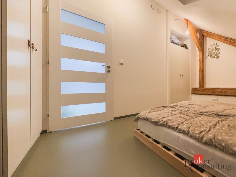 A bedroom with wooden elements, a pallet bed, and storage space in a three-room apartment.