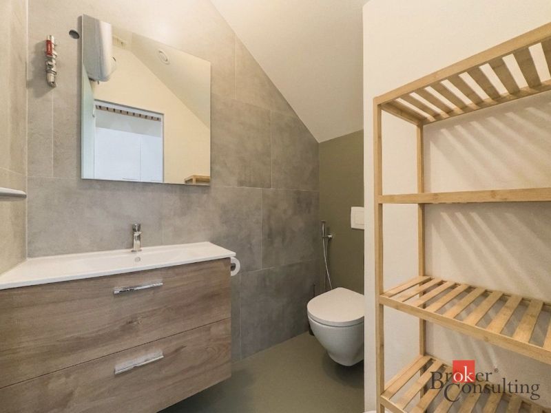 Bathroom in a 3-room apartment with a sink, wooden shelf, and a mirror on the wall.