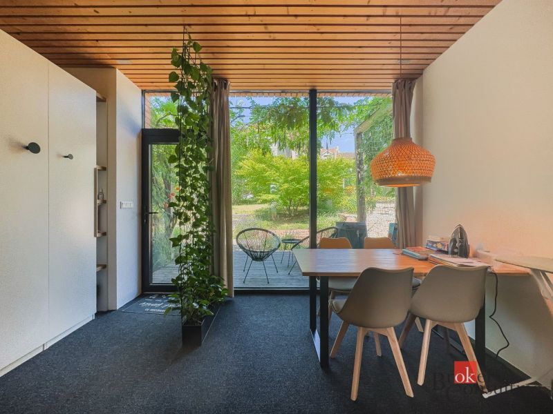 Dining area in a 3-room apartment with large windows and a garden.