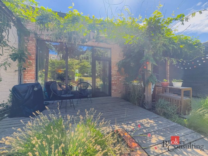 A terrace with greenery, wooden decor, and garden seating of a 3-room apartment.