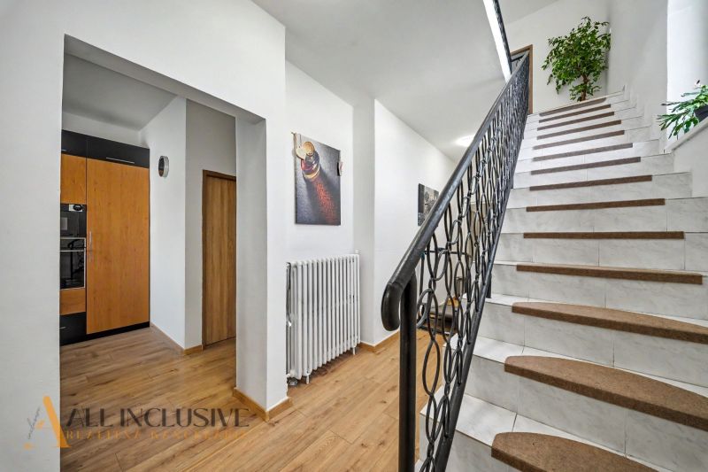 A staircase with white steps and a wooden decor floor in a family house.