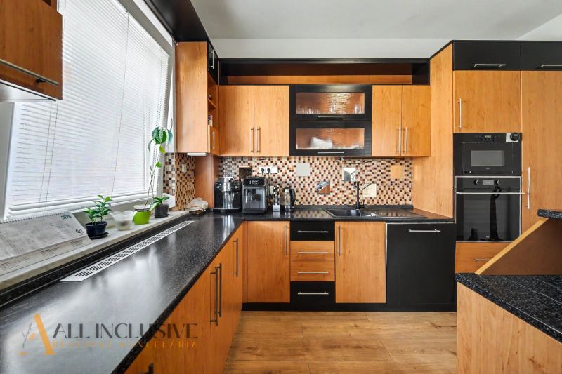 A kitchen in a family house with wooden decor and modern equipment.
