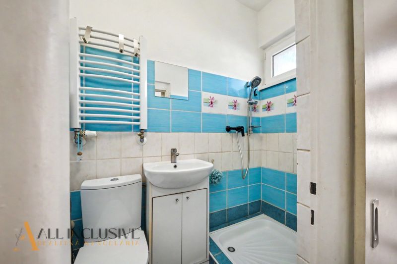 A bathroom in a family house with white sanitary ware and blue tiles.