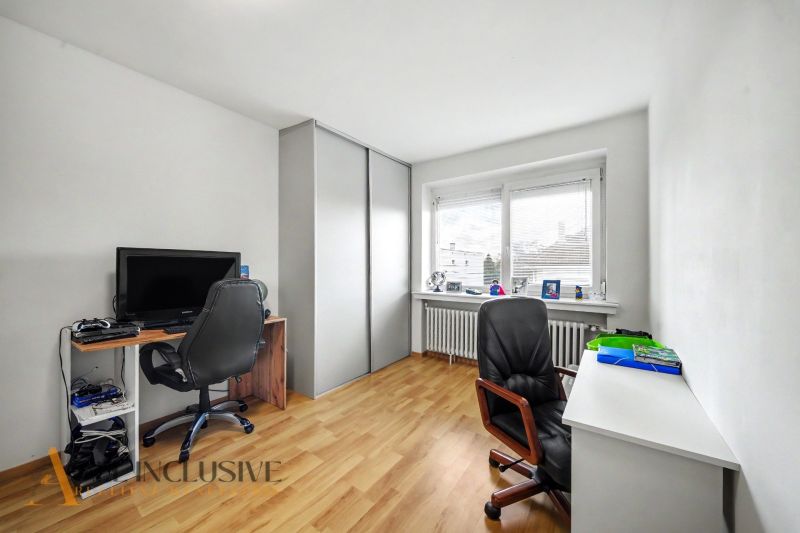 A home office with a computer and wood-patterned flooring in a family house.