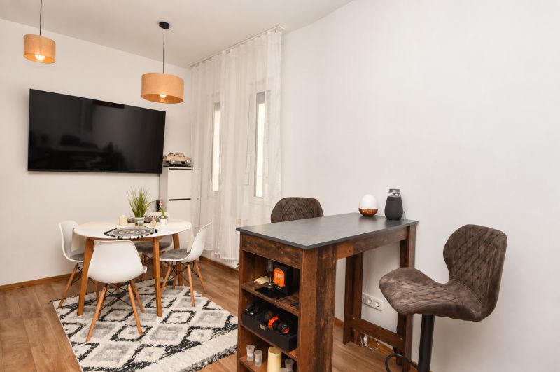 Interior of a 1-room apartment with a wooden decor floor and a dining table.