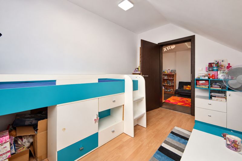 A children's room in a family house with colorful furniture and a wooden decor floor.
