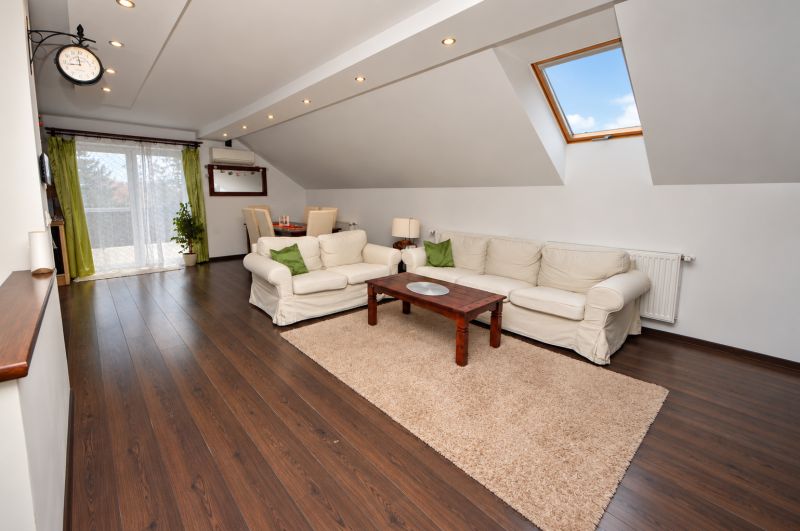 Attic living space with wood-decor flooring in a family house.