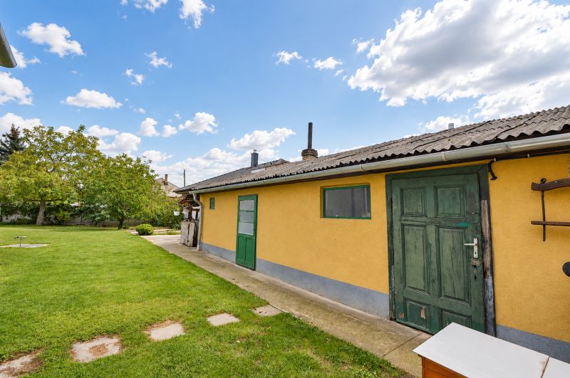 The garden of a family house in Mosonmagyaróvár with a lawn and trees.