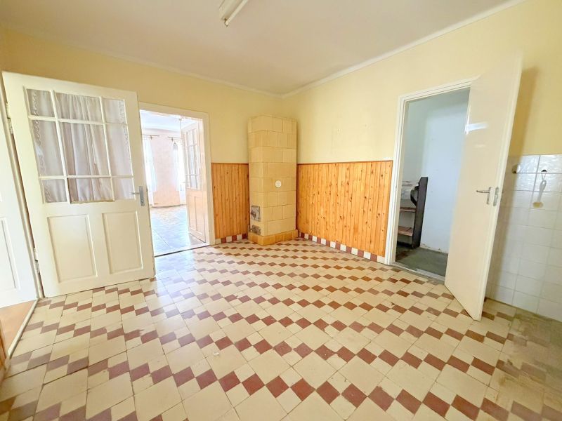 A room in a family house with tiled flooring and wooden wall paneling.