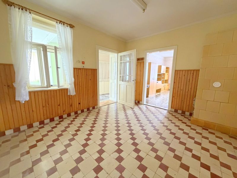 Interior of a family house, a bright room with a tiled floor and wooden wall paneling.