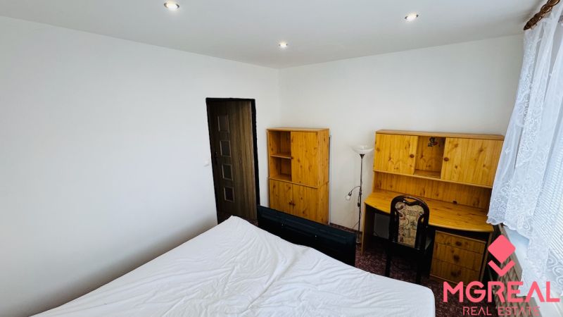 A room with a desk and wooden furniture in a 3-room apartment.