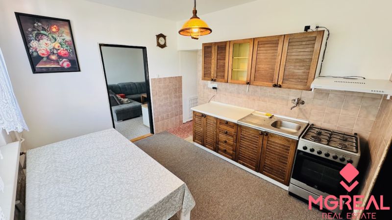 A kitchen in a 3-room apartment with a gas stove and a kitchen unit with a wooden decor.