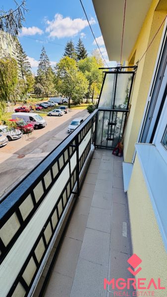 A balcony with a view of trees and cars on Nádražná Street in Partizánske, the space of a 3-room apartment.