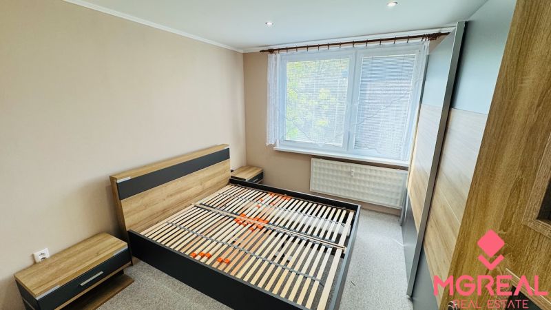 Bedroom with a bed, nightstands, and a large wardrobe in a 3-room apartment.