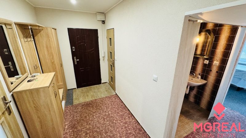 A hallway in a 3-room apartment with built-in wardrobes and a sink with lighting.