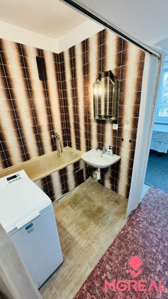 A bathroom with retro tiles and a bathtub, a washing machine in a 3-room apartment.