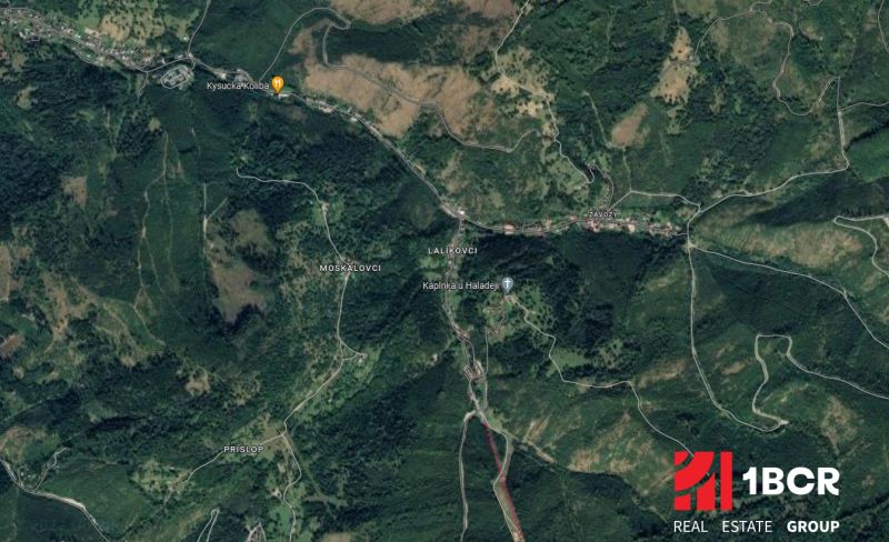 Aerial view of Oščadnica with surrounding forested areas, roads, and buildings.