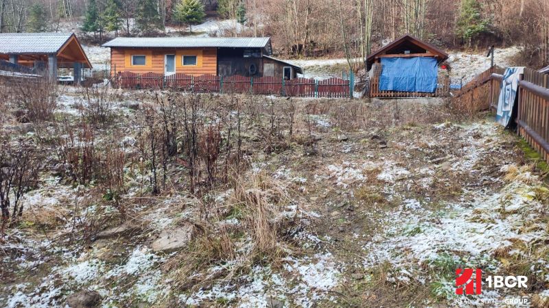 Wooden cabins on a snowy slope in Oščadnica near a family house.