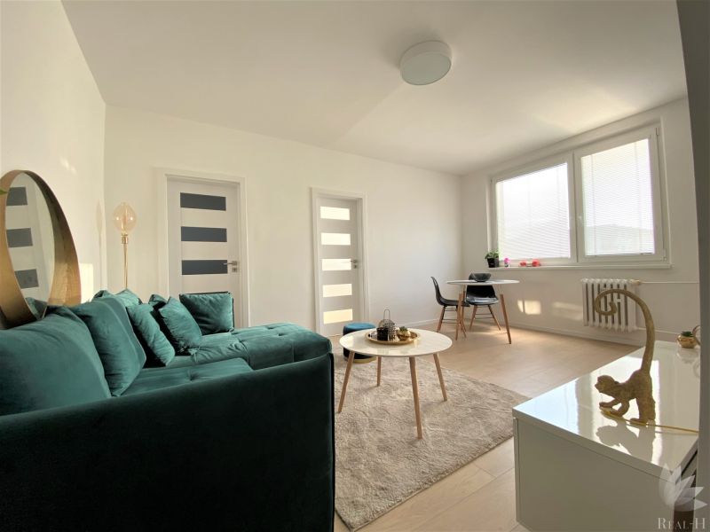 Bright living room in a 3-room apartment with a sofa, table, and dining area.