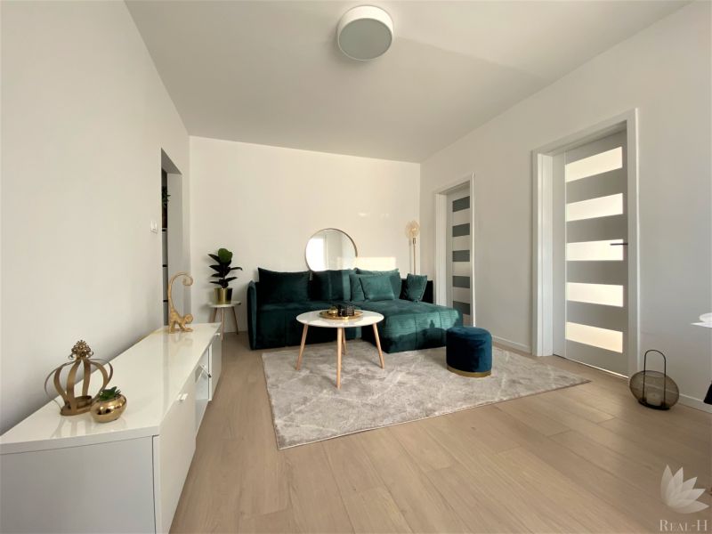 Living room with a sofa and decorations in a 3-room apartment, bright interior.