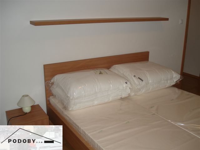 Bedroom in a 3-room apartment with a bed and a nightstand with a lamp.