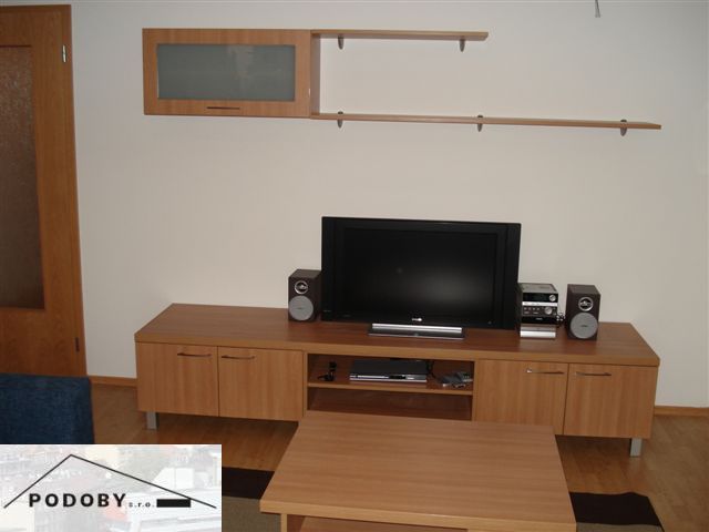 Living room in a 3-room apartment with a wooden decor floor, television, and furniture.