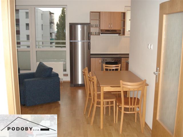 Kitchen connected with dining room, wooden floor decor, seating in a 3-room apartment.