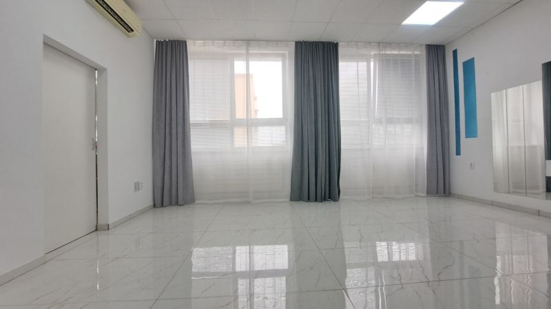 Spacious commercial spaces with large windows and white tiles on the floor.