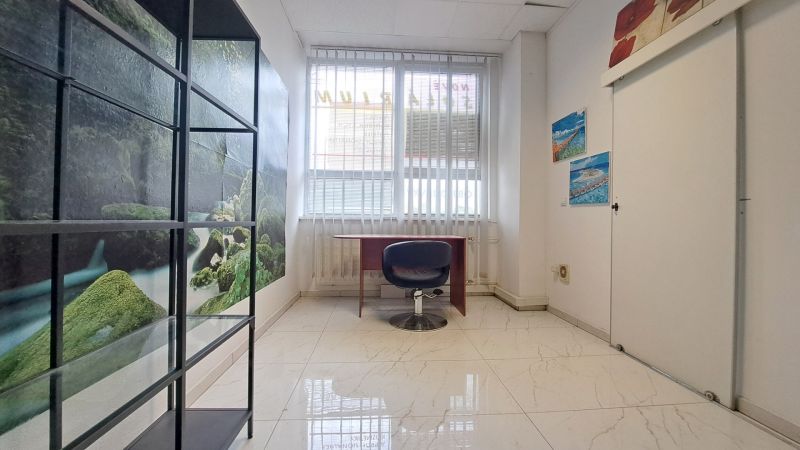 Office with white tiles and decorative paintings.