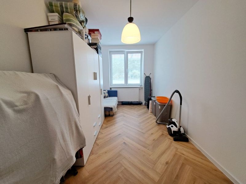 A bright room in a 3-room apartment with a wooden decor floor and storage space.