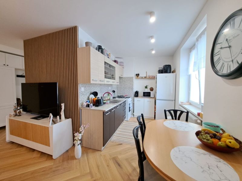 Kitchen and dining room in a 3-room apartment with a wooden decor floor.