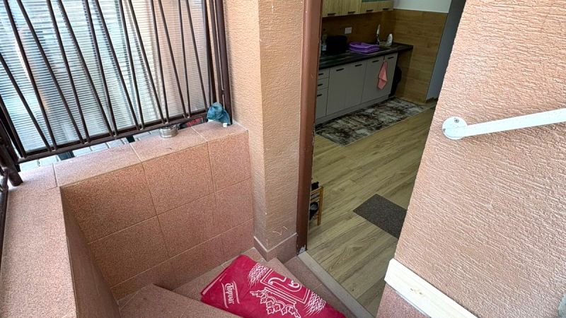Stairs and a kitchen with wood-patterned flooring in a family house.
